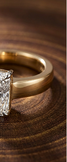 Gold ring with a diamond on a wooden surface