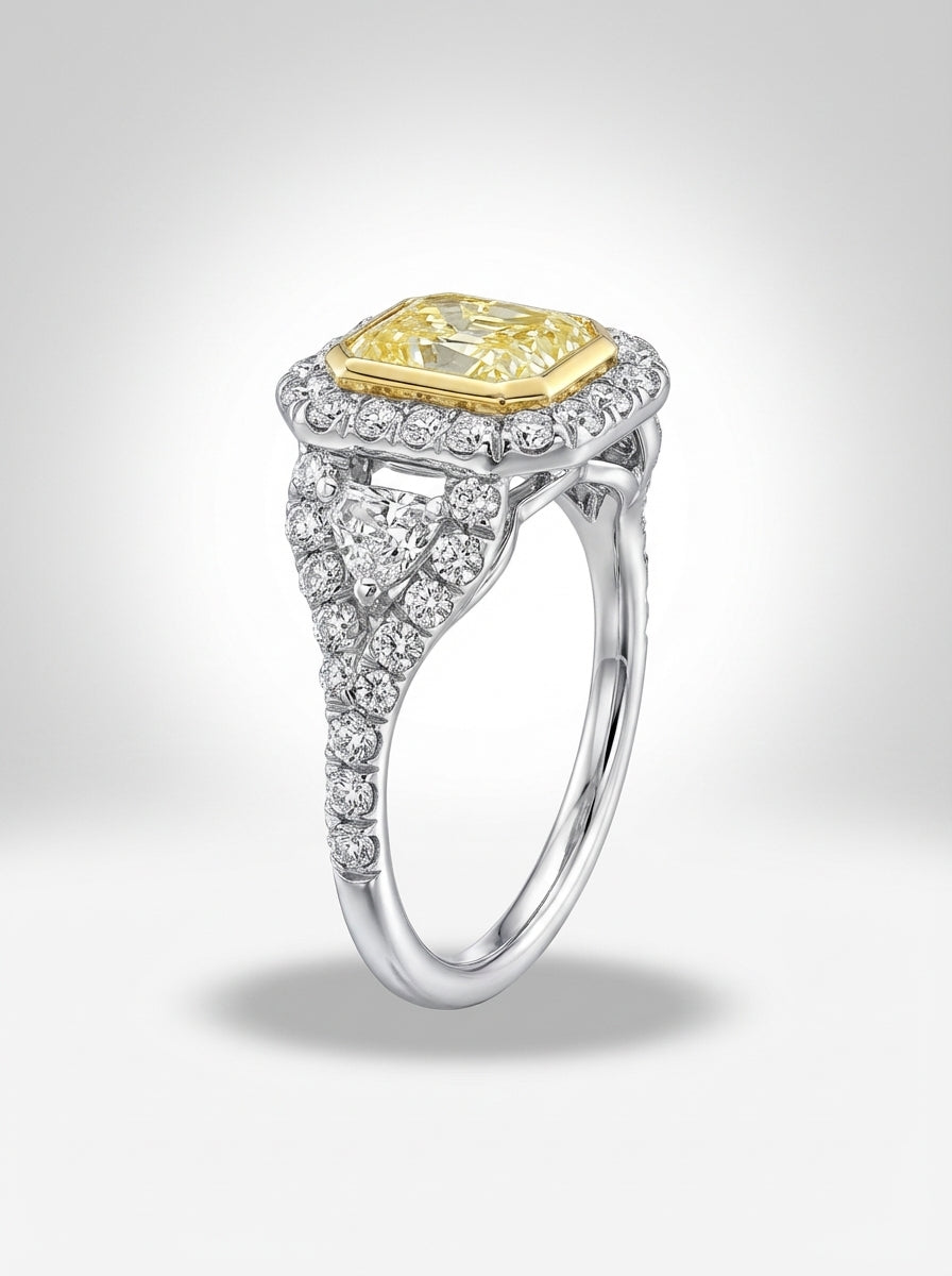 Diamond ring with yellow center stone and silver band on a light gray background