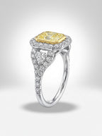 Diamond ring with yellow center stone and silver band on a light gray background