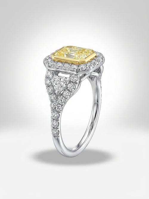 Diamond ring with yellow center stone and silver band on a light gray background