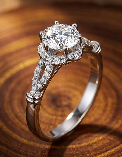 White gold engagement ring featuring a round center diamond, sparkling halo, and a split pavé band.